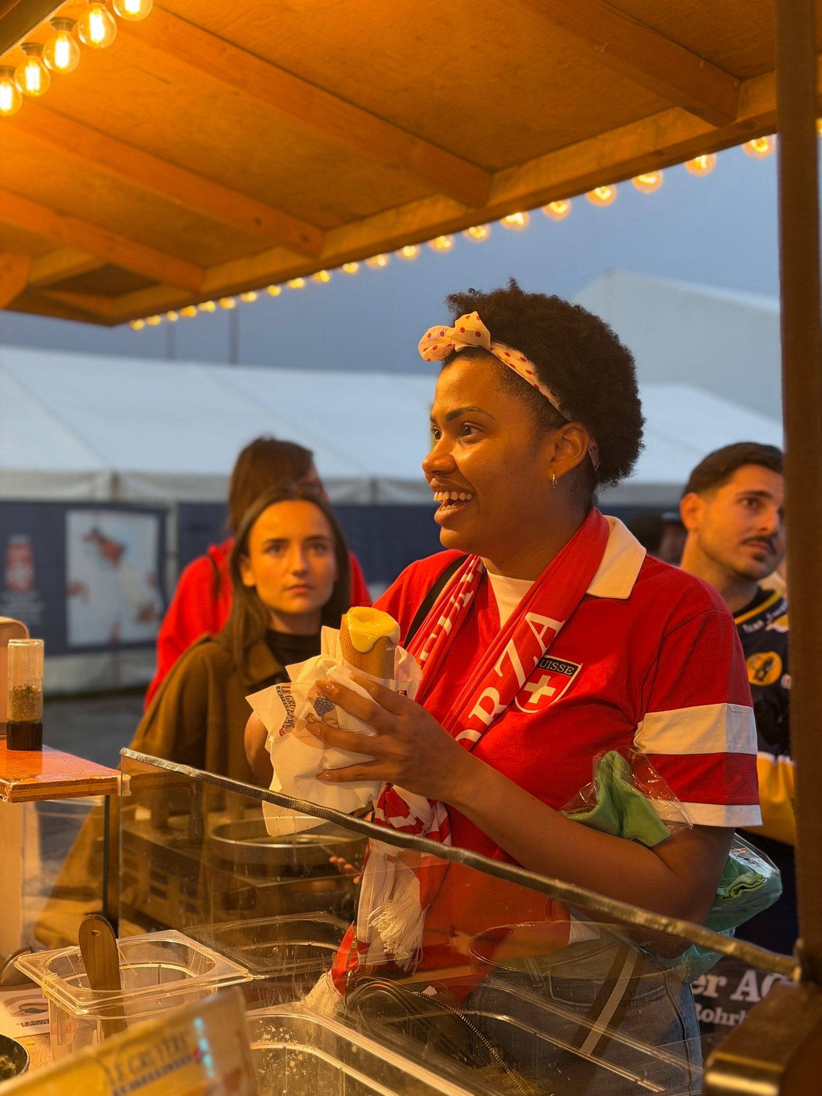 Supportrice suisse dégustant un Hot Fondue Le Gruyère AOP dans la fan zone