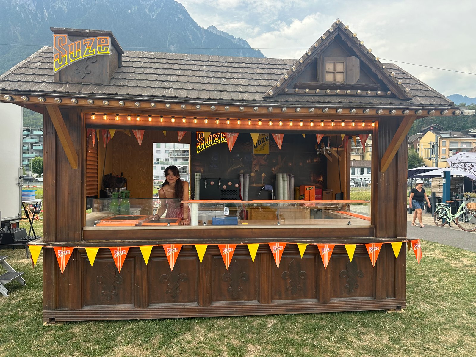 Ardoise des tarifs du bar Suze et comptoir garni pendant la fête nationale