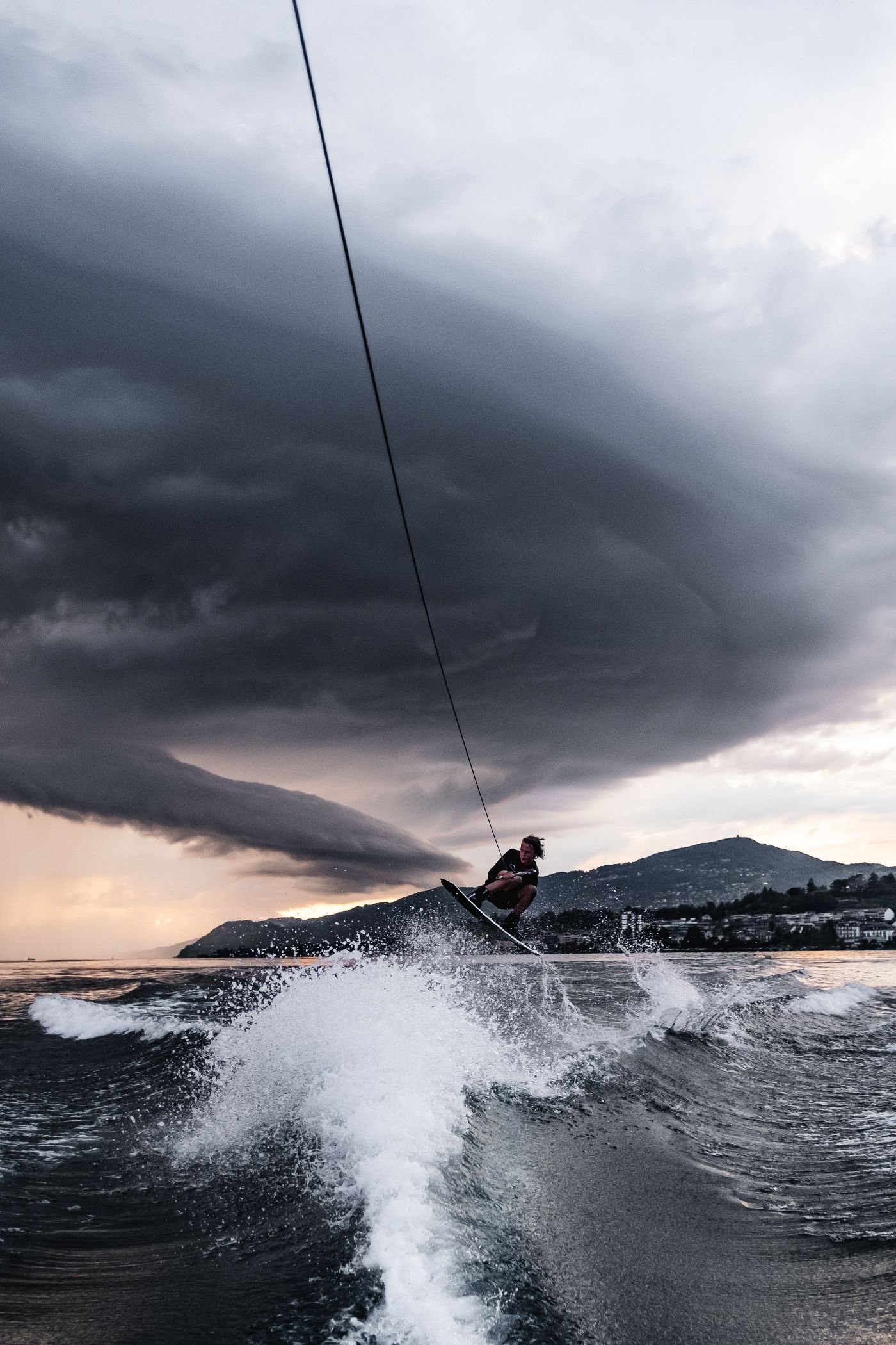 Rider de wakeboard en saut devant un ciel d'orage sur le lac Léman
